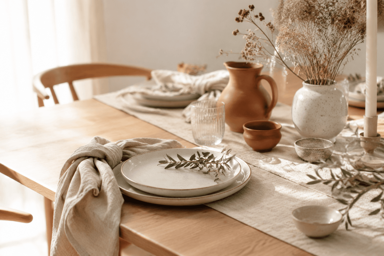 A styled dining table dressed in natural linen napkins and a runner in soft daylight